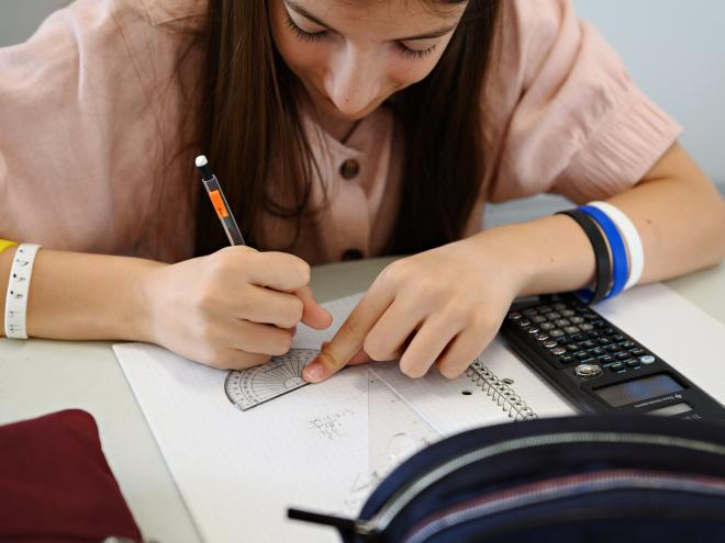 A student working through a mathematics contest problem on paper